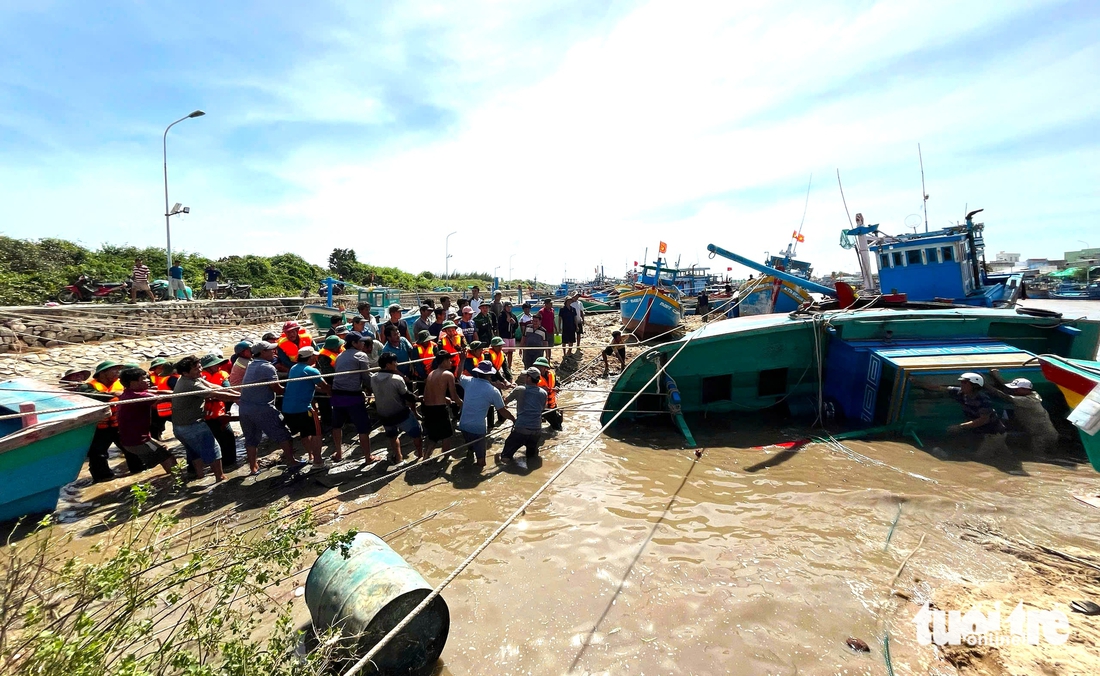 Ngư dân xót xa trục vớt tàu cá chìm ở cửa biển Liên Hương sau lũ - Ảnh 1.