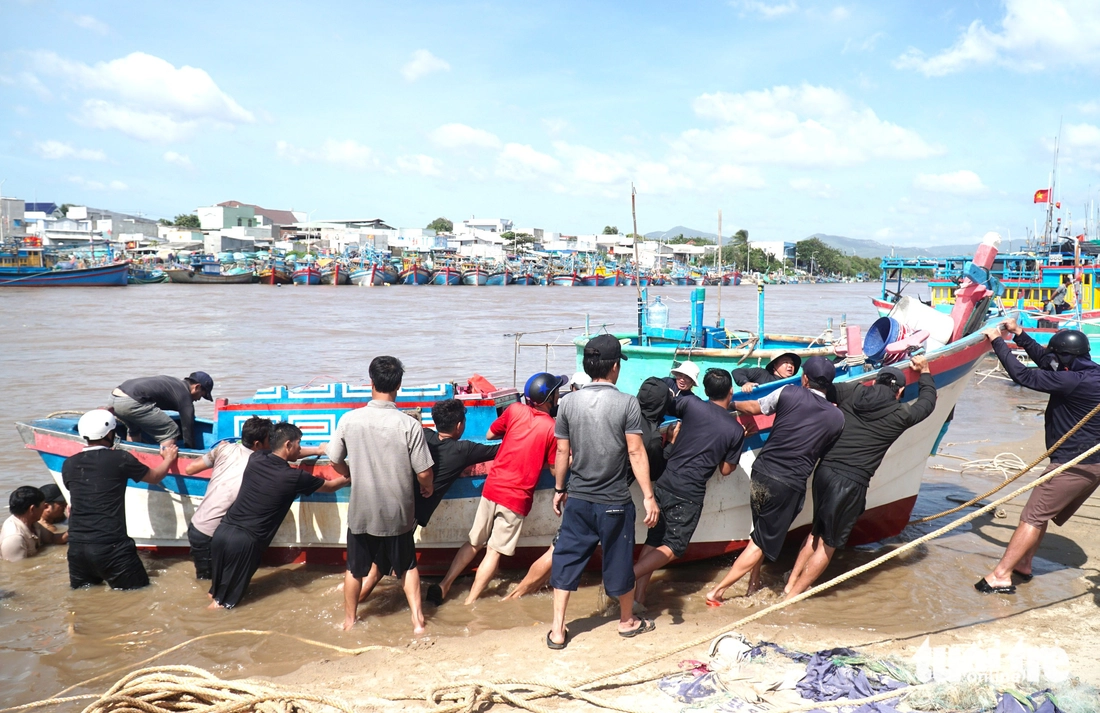 Ngư dân xót xa trục vớt tàu cá chìm ở cửa biển Liên Hương sau lũ - Ảnh 2.