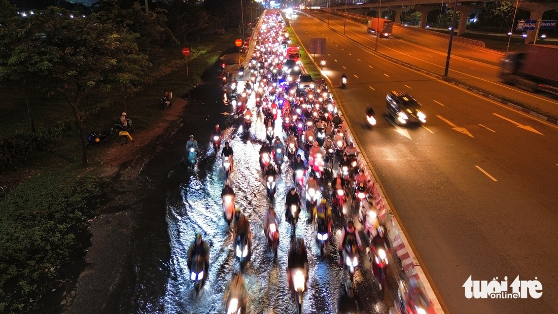 Nước cống tràn lên mặt đường Võ Nguyên Giáp vì triều cường, hàng ngàn xe máy 'bò' qua đoạn ngập - Ảnh 2.
