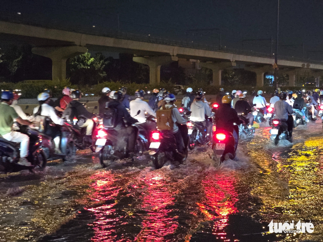 Nước cống tràn lên mặt đường Võ Nguyên Giáp vì triều cường, hàng ngàn xe máy 'bò' qua đoạn ngập - Ảnh 4.