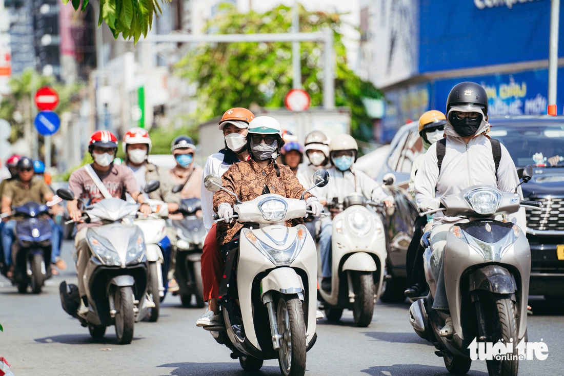 TP.HCM nắng nóng ‘đổ lửa’, người dân tìm đến tán cây, tài xế công nghệ dùng thuốc chống say nắng - Ảnh 1.