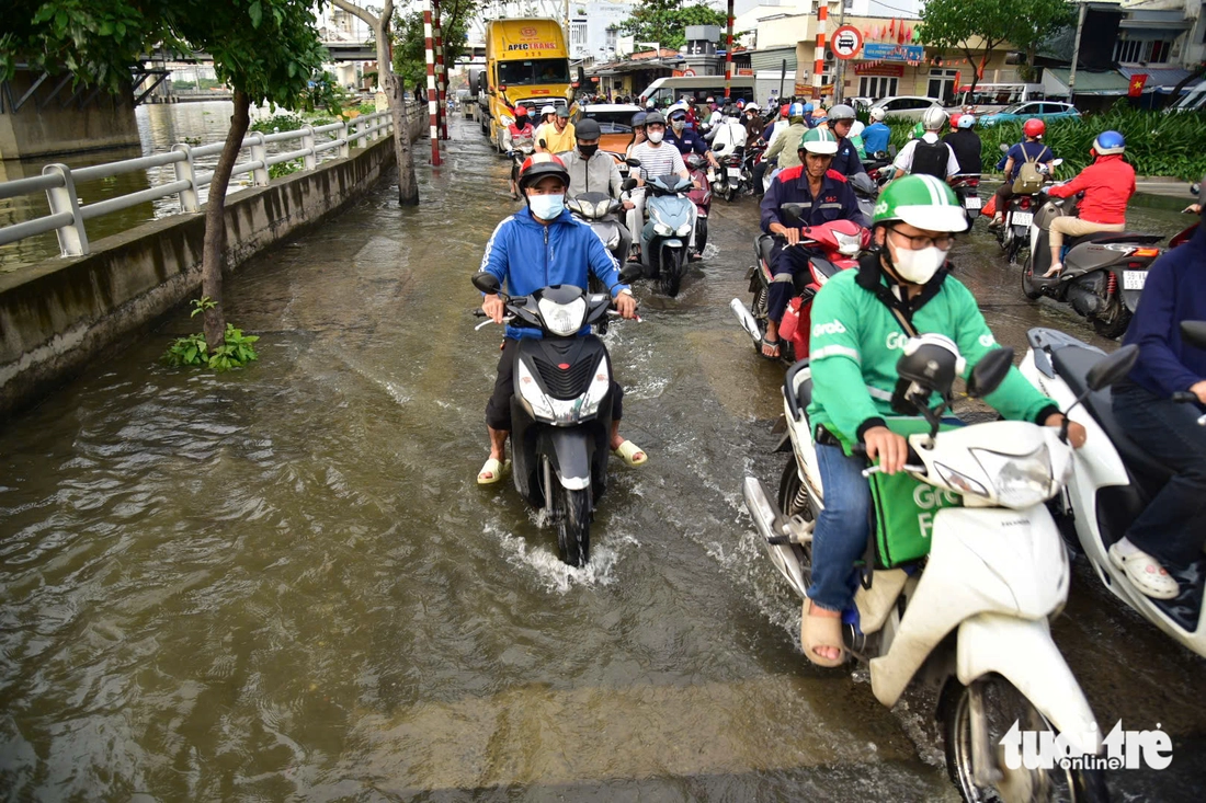 Triều cường đạt đỉnh, người dân TP.HCM lại bì bõm giờ tan tầm - Ảnh 4.