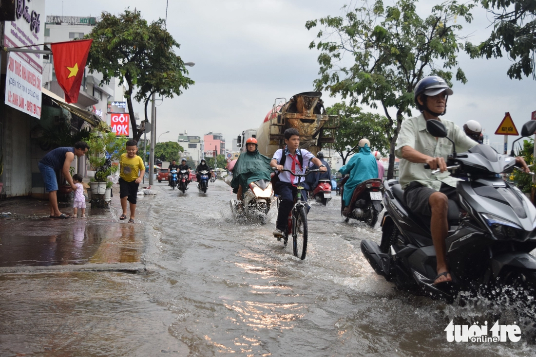 Triều cường kết hợp mưa gây ngập, người dân TP.HCM bì bõm giờ tan tầm - Ảnh 4.