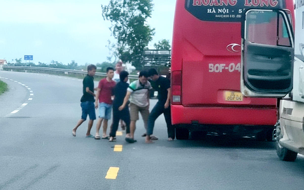 Xe khách và xe container đang chạy thì dừng lại, người trên xe lao xuống đánh nhau