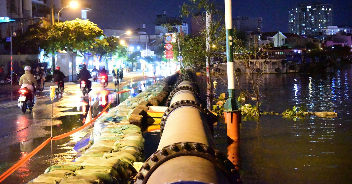 Đắp bao cát ngăn nước kênh Tẻ tràn vào đường Trần Xuân Soạn khi triều cường