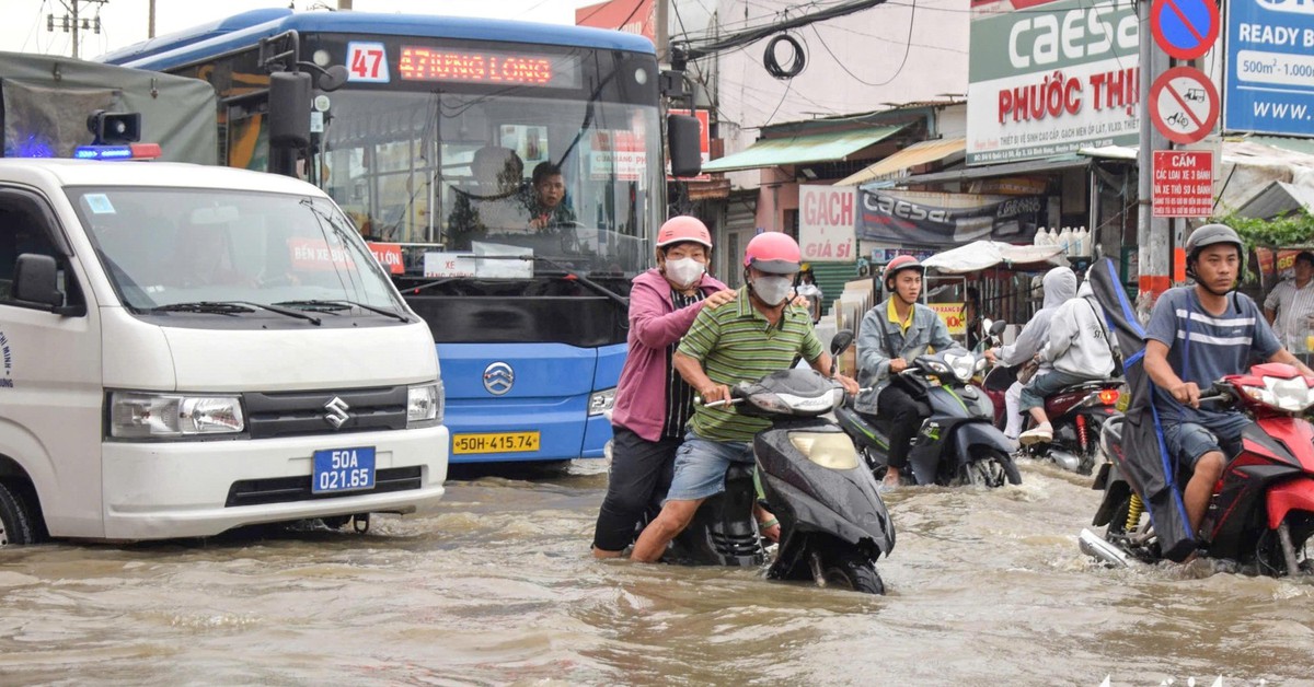 Đường Văn Tiến Dũng ‘chìm’ trong triều cường, người dân chung tay căng bạt, đắp cát ngăn nước