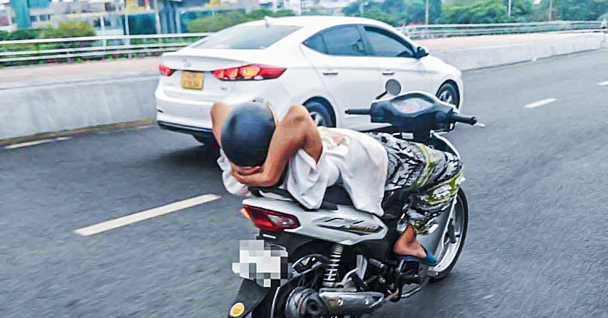 Người đàn ông 39 tuổi thả 2 tay, nằm ngửa trên xe máy chạy qua cầu Rồng
