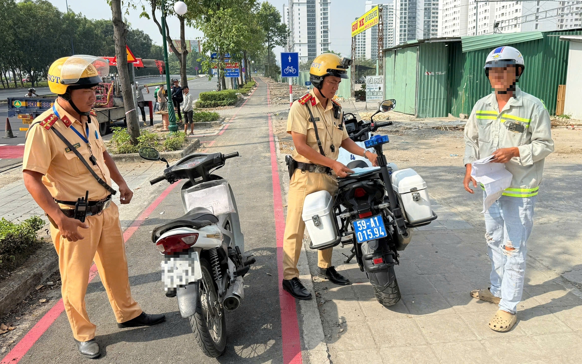 Cảnh sát giao thông xử phạt người chạy xe máy vào làn dành riêng cho xe đạp trên đường Mai Chí Thọ