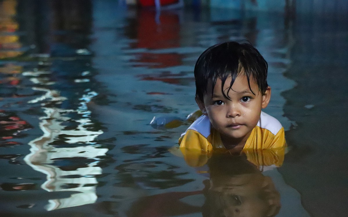 Người dân đắp ‘đê’ trước cửa nhà, trẻ em bơi giữa dòng triều cường đạt đỉnh tại TP.HCM