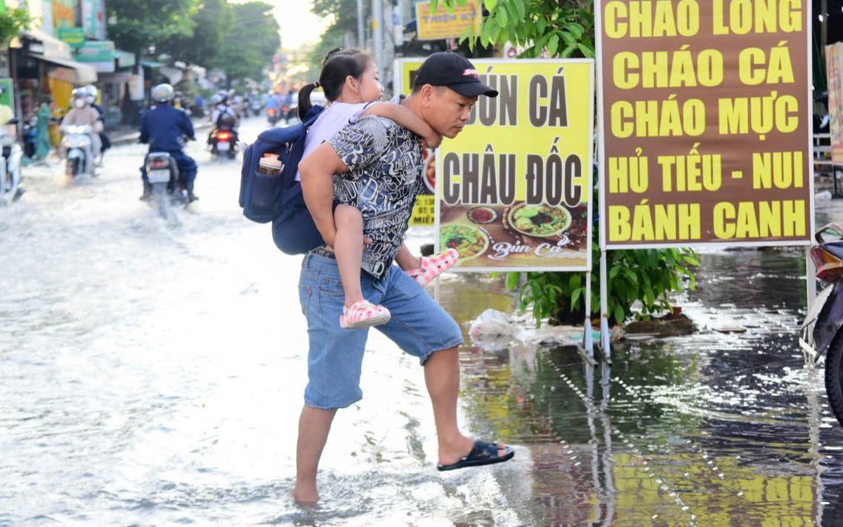 Ngập vì triều cường, người dân ở đường Bùi Văn Ba, TP.HCM cặm cụi dọn nhà từ sáng sớm