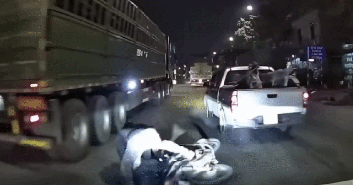 Ô tô chèn ép làm xe máy chở trẻ em ngã ra đường, ngay sát gầm xe tải