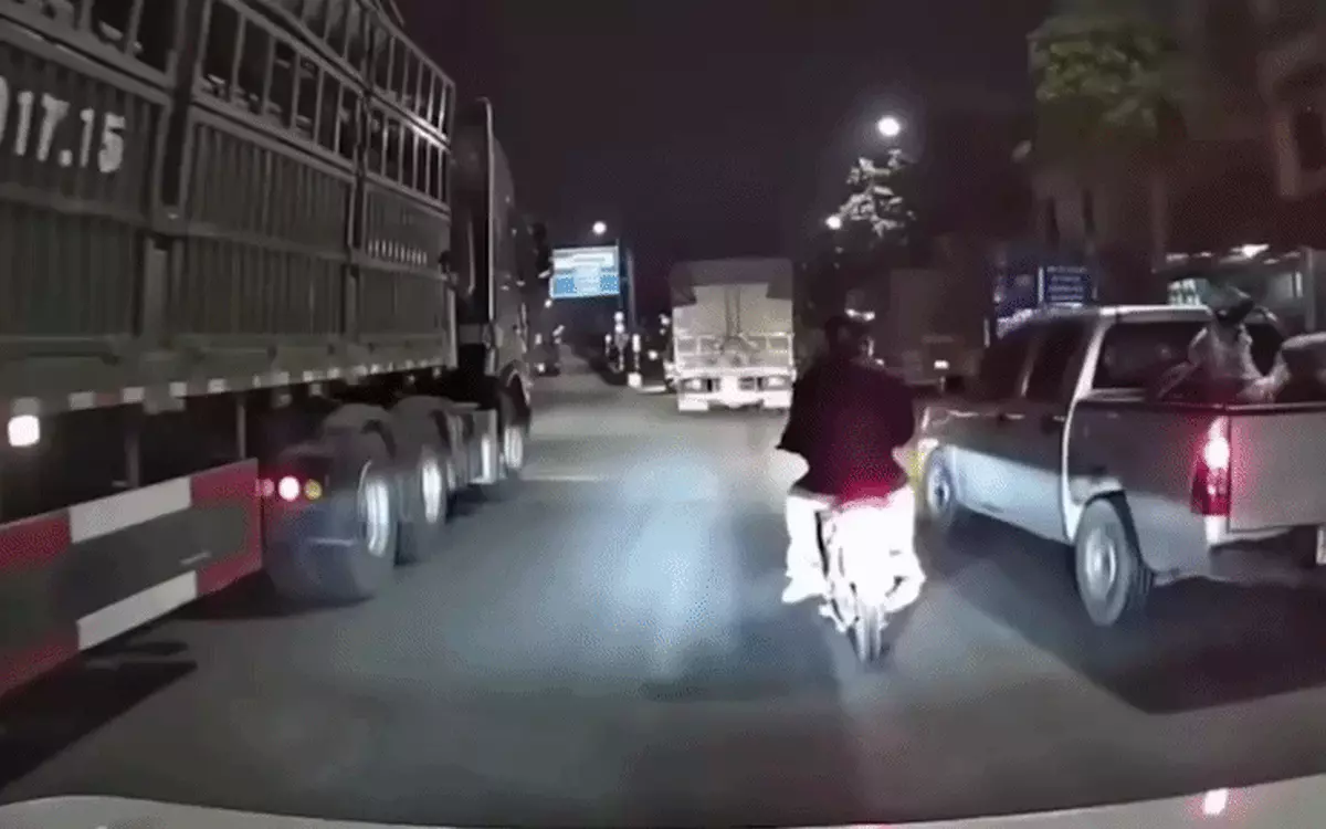 Ô tô chèn ép làm xe máy chở trẻ em ngã ra đường, ngay sát gầm xe tải