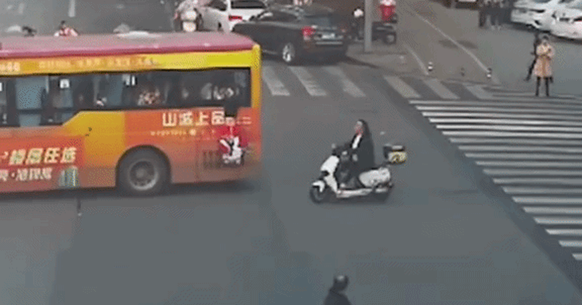 Bé gái treo lơ lửng ngoài cửa sổ xe buýt đang chạy, người đi xe máy lao tới cứu