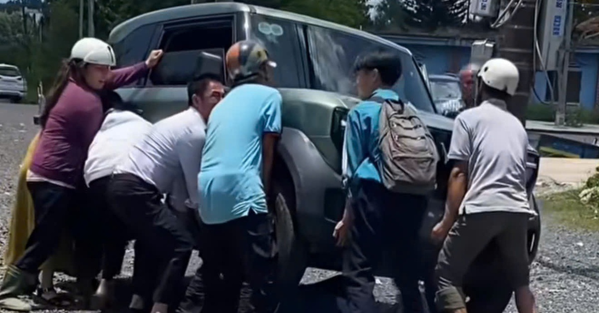 Người lớn, trẻ em hợp sức nâng ô tô điện cứu học sinh kẹt dưới gầm