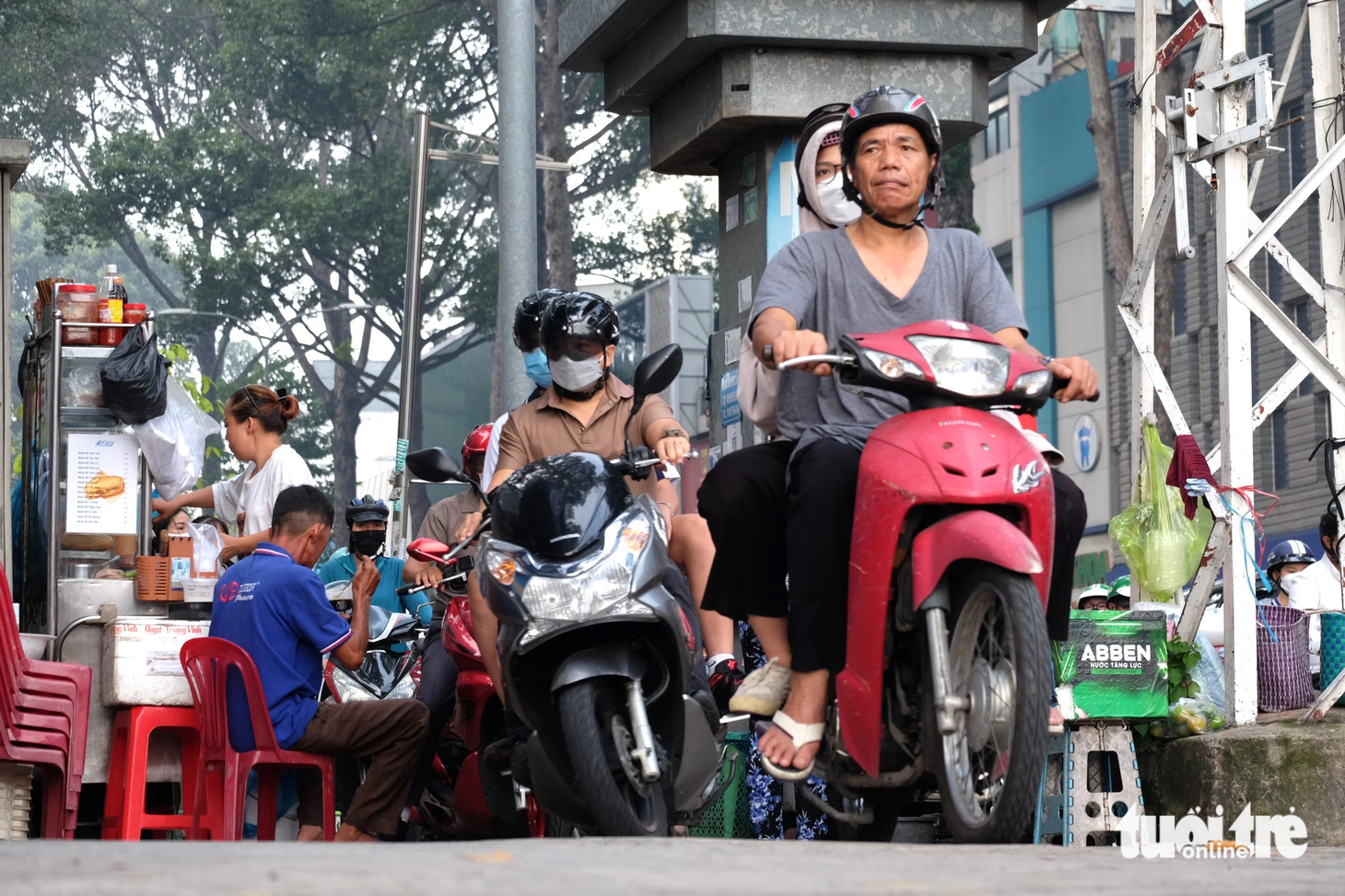 Tại đường 3 Tháng 2 đoạn dẫn về vòng xoay Công trường Dân Chủ, dưới lòng đường là dòng xe cộ nhích từng chút một. Trên vỉa hè, rất nhiều xe máy luồn lách giữa những xe hàng rong để di chuyển nhanh qua giao lộ - Ảnh: PHƯƠNG NHI