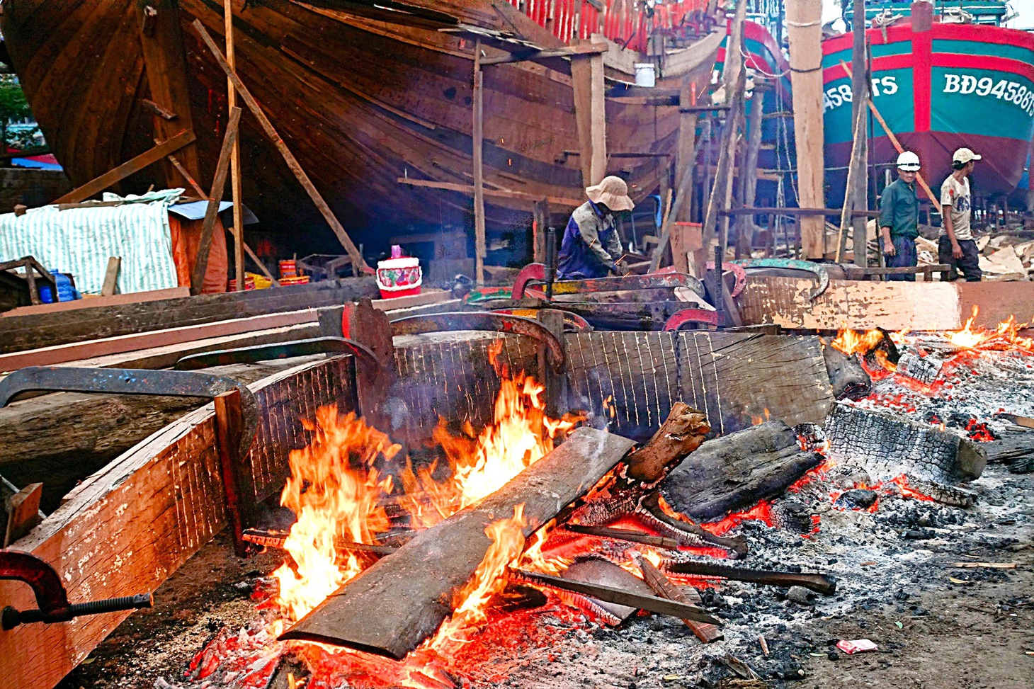 Những tấm ván mới được thợ hơ lửa uốn cong khớp với độ cong của con tàu