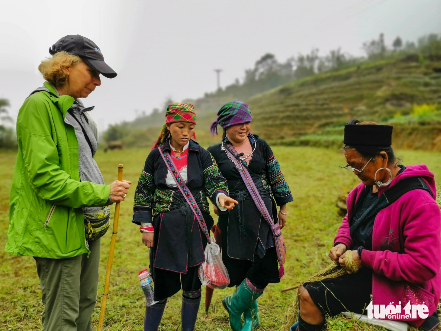Không biết đọc tiếng Việt, nhưng Lý Thị Cở nói làu làu tiếng Anh để thuyết trình cho du khách nước ngoài hiểu về nghề đan thổ cẩm của đồng bào mình Ảnh VŨ TUẤN