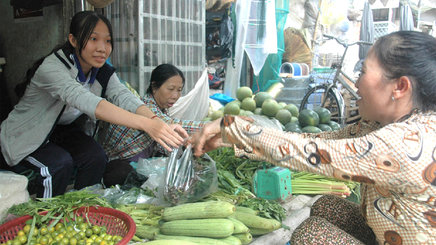 Ngoài giờ học, Nguyễn Thị Kiều Loan (trái) lại ra chợ phụ mẹ bán rau lo cuộc sống của cả nhà - Ảnh: LƯ THẾ NHÃ