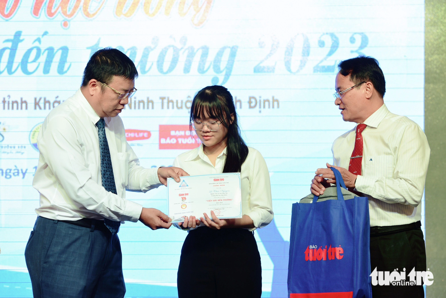 Ông Võ Hoàn Hải - Giám đốc sở Giáo dục - Đào tạo tỉnh Khánh Hòa (bên trái) - cùng nhà báo Nguyễn Hoàng Nguyên - Phó tổng biên tập báo Tuổi Trẻ trao học bổng cho các tân sinh viên có hoàn cảnh khó khăn - Ảnh: DUYÊN PHAN