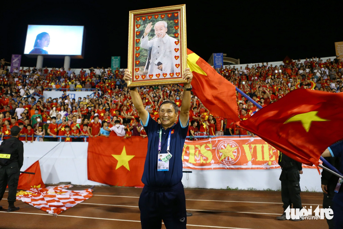 HLV Mai Đức Chung giương cao ảnh Bác Hồ ăn mừng sau khi cùng đội tuyển nữ Việt Nam giành HCV SEA Games 31 tại Việt Nam - Ảnh: HOÀNG TÙNG