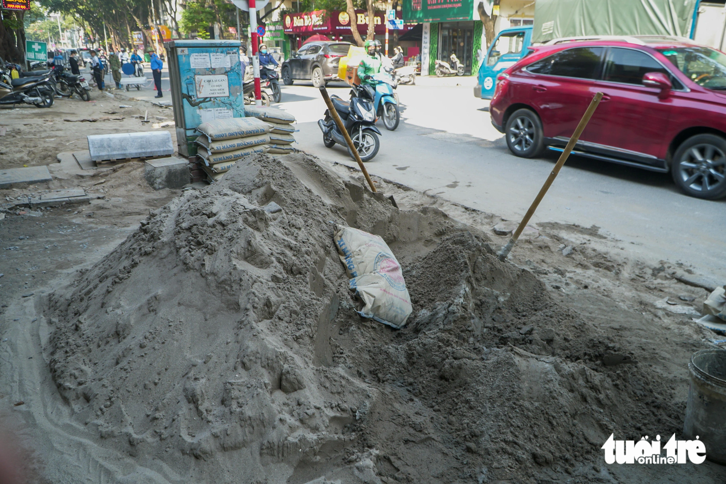 Những đống xi măng trộn cát lớn trên vỉa hè cản trở việc đi lại của người dân - Ảnh: PHẠM TUẤN