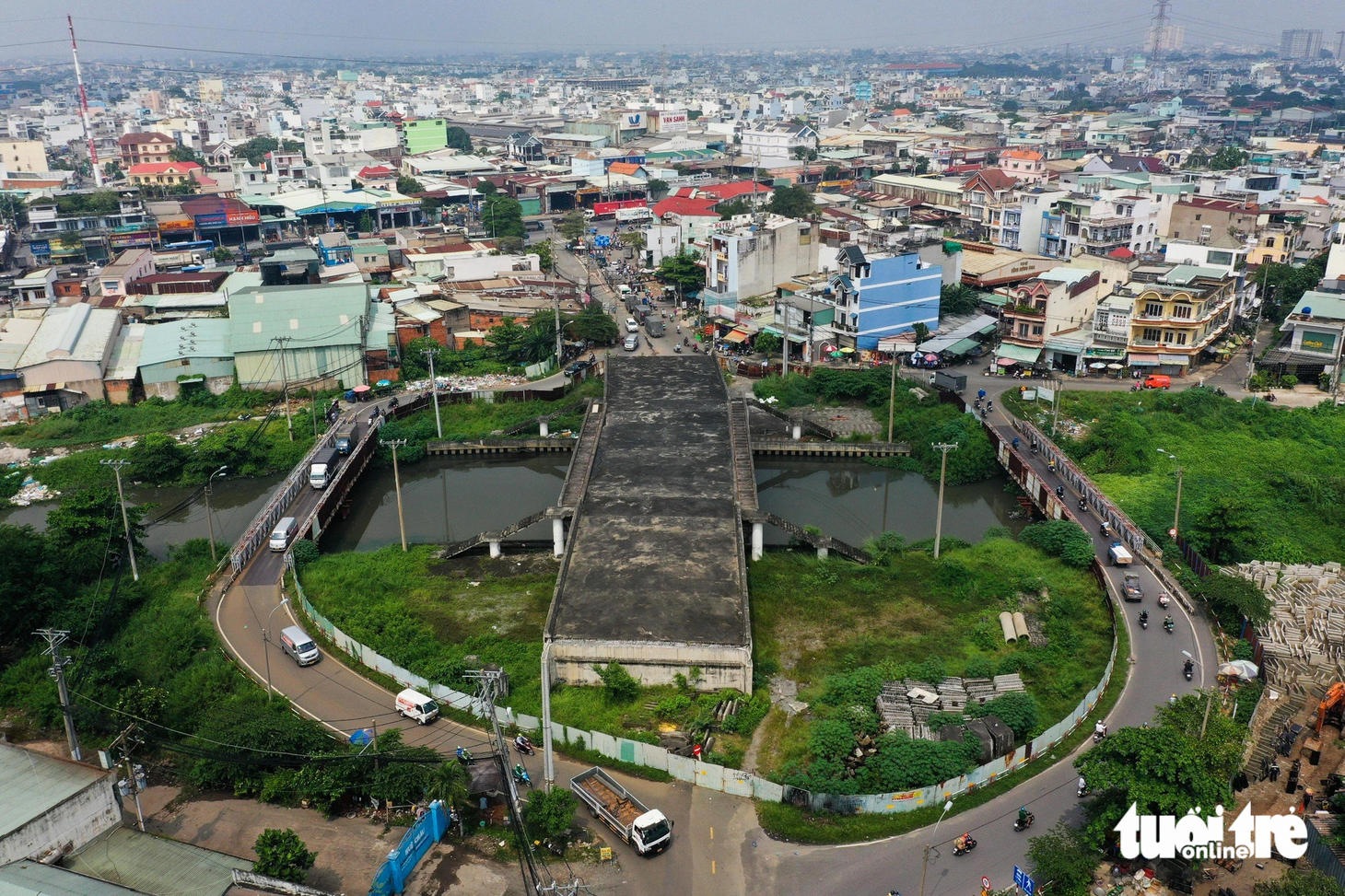 Cầu Tân Kỳ - Tân Quý (phường Bình Hưng Hòa, quận Bình Tân) đã hoàn thành phần giữa cầu bắc qua kênh Tham Lương, hai bên là cầu tạm bằng sắt để người dân đi lại - Ảnh: PHƯƠNG NHI