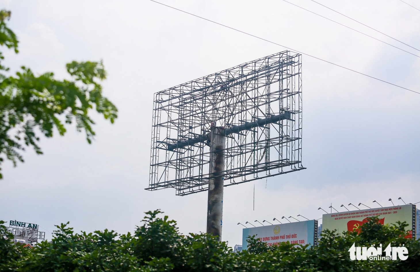 Bảng quảng cáo này đang được sửa chữa, dựng đứng trở lại. Trên cột bảng quảng cáo vẫn còn ám màu hoen gỉ, khói đen sau 2 năm đổ sập. Ghi nhận ngày 10-12 - Ảnh: LÊ PHAN