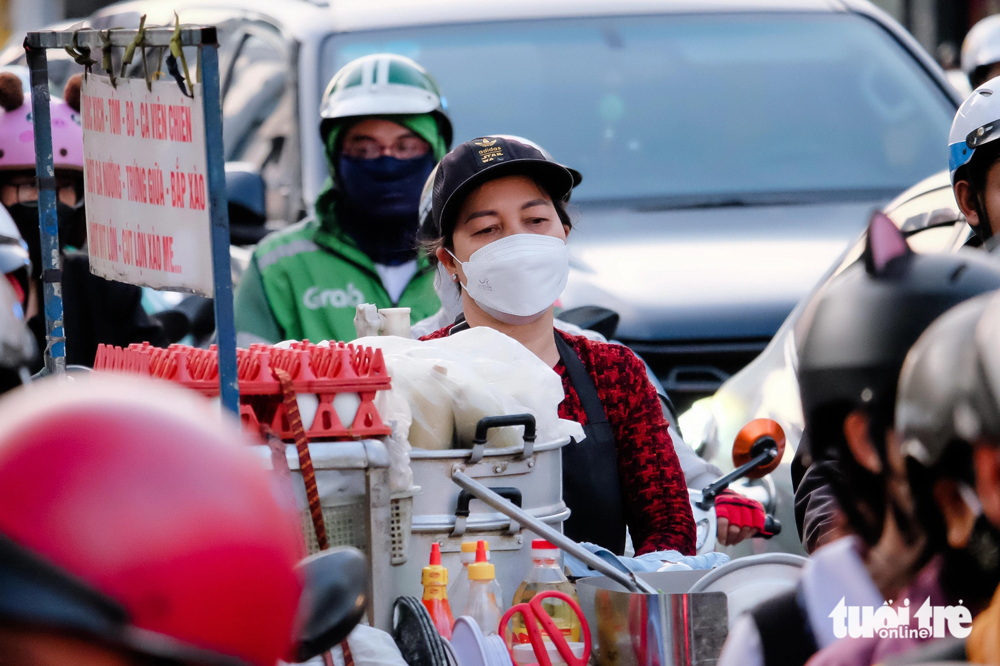 Một phụ nữ đẩy xe hàng rong mệt mỏi vì đã "đứng im" giữa đường Cộng Hòa, đoạn giao với đường Bình Giã được 15 phút