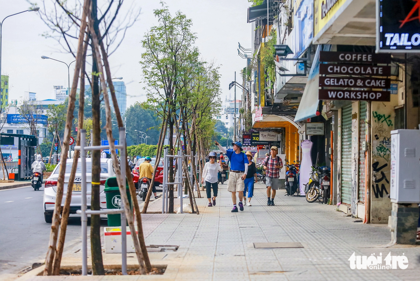 Người dân và du khách thích thú khi thấy hàng cây me xanh vừa được trồng - Ảnh: CHÂU TUẤN