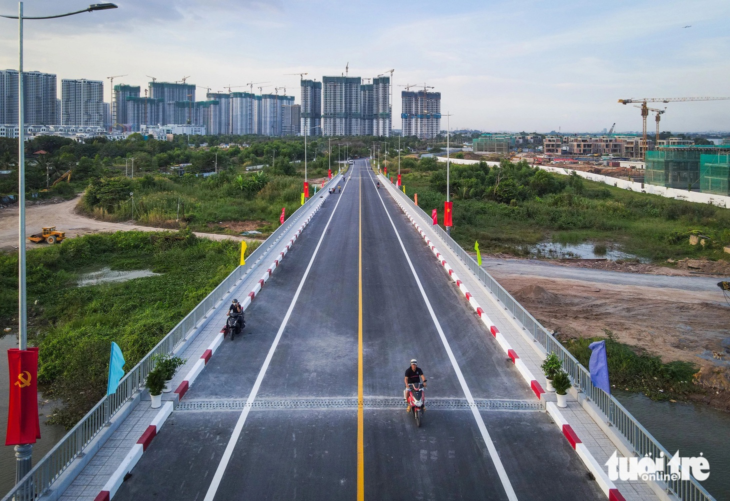 Dù chưa thông xe nhưng một số người dân tò mò, chạy qua xem cây cầu mới ra sao - Ảnh: CHÂU TUẤN