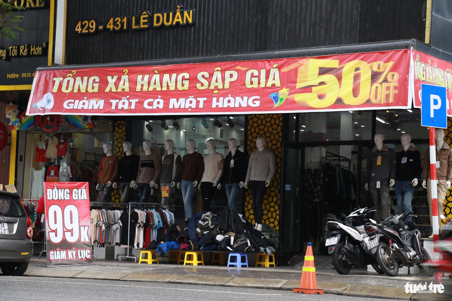 Các cửa hàng tích cực treo biển xả hàng, giảm giá và dọn ra cả vỉa hè vẫn không có khách đoái hoài - Ảnh: ĐOÀN NHẠN