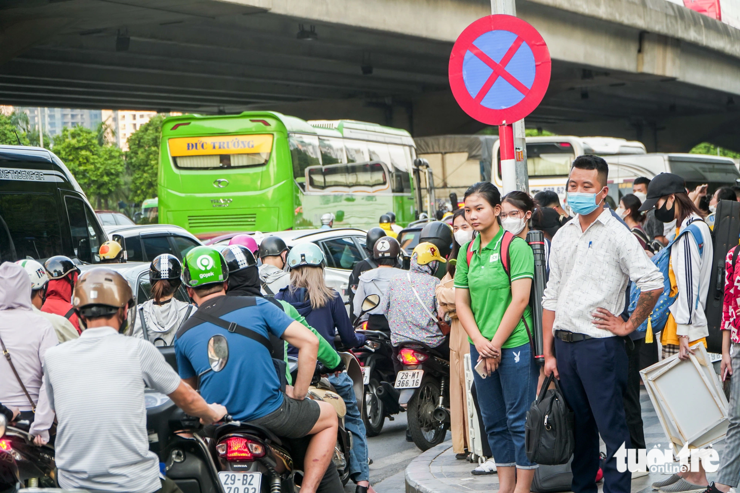 Nhiều người dân "tay xách nách mang" ra cạnh vỉa hè đợi để bắt xe về quê - Ảnh" PHẠM TUẤN