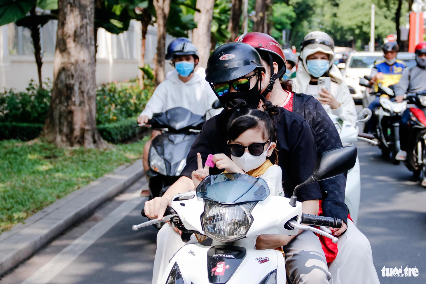 Một gia đình chở con nhỏ đi dạo - Ảnh: TIẾN QUỐC