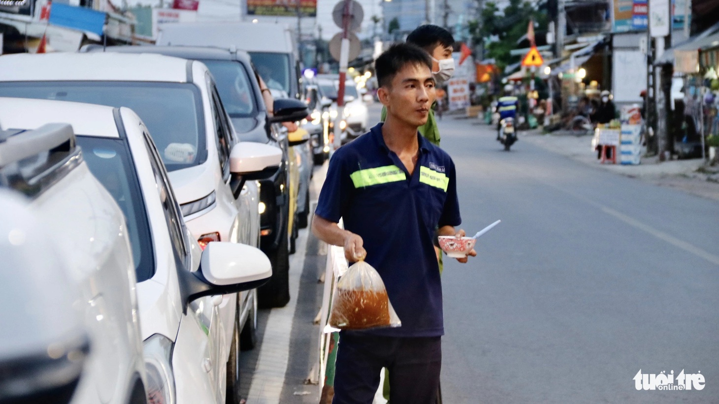 Có người phải gọi đồ ăn đến tận xe lót dạ khi trời đã gần tối mà vẫn chưa qua được phà - Ảnh: TIẾN QUỐC