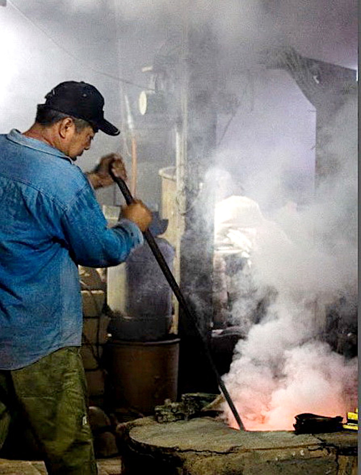 Thợ lành nghề giữ nhiệt cho lò và đổ đồng chảy vào khuôn