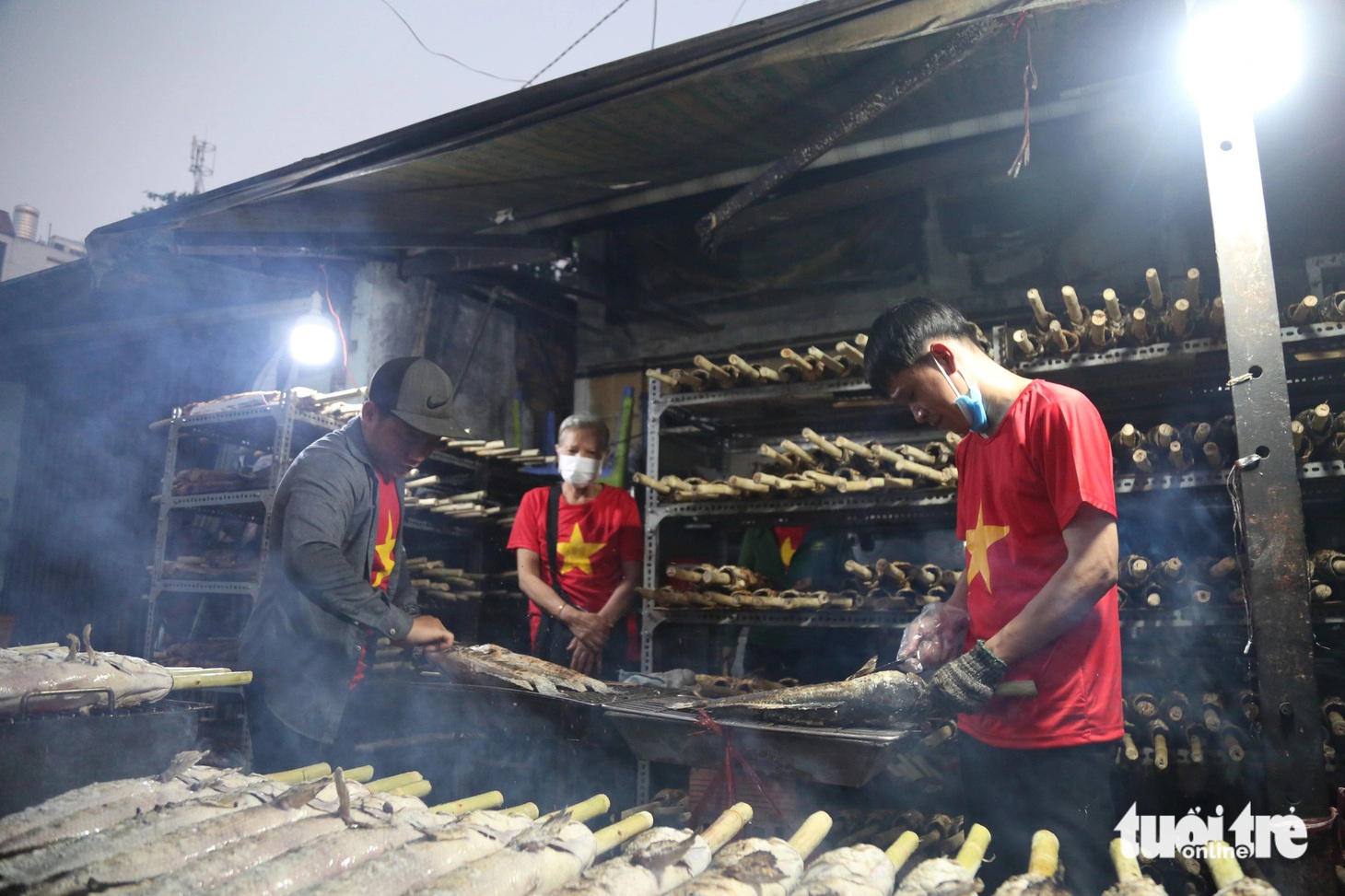 Từ tối qua (18-2) cho đến sáng nay (19-2), các gian hàng bán cá lóc nướng trên đường Tân Kỳ Tân Quý (quận Tân Phú, TP.HCM) hoạt động hầu như hết công suất - Ảnh: PHƯƠNG QUYÊN