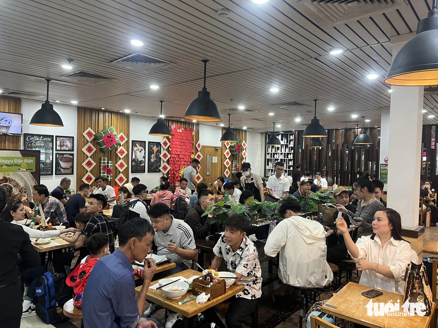 Khu vực ăn uống đông nghẹt người. Cửa hàng bán cà phê, phở, bánh mì nườm nượp khách mua đồ ăn, ngồi chờ chuyến bay có giờ khởi hành mới - Ảnh: C.TRUNG