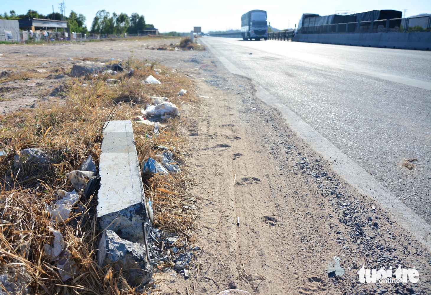 Xe ra vào bãi đất trống bên hông cao tốc tại Km 219, tông gãy cọc tiêu phản quang, rác cũng tràn ngập.