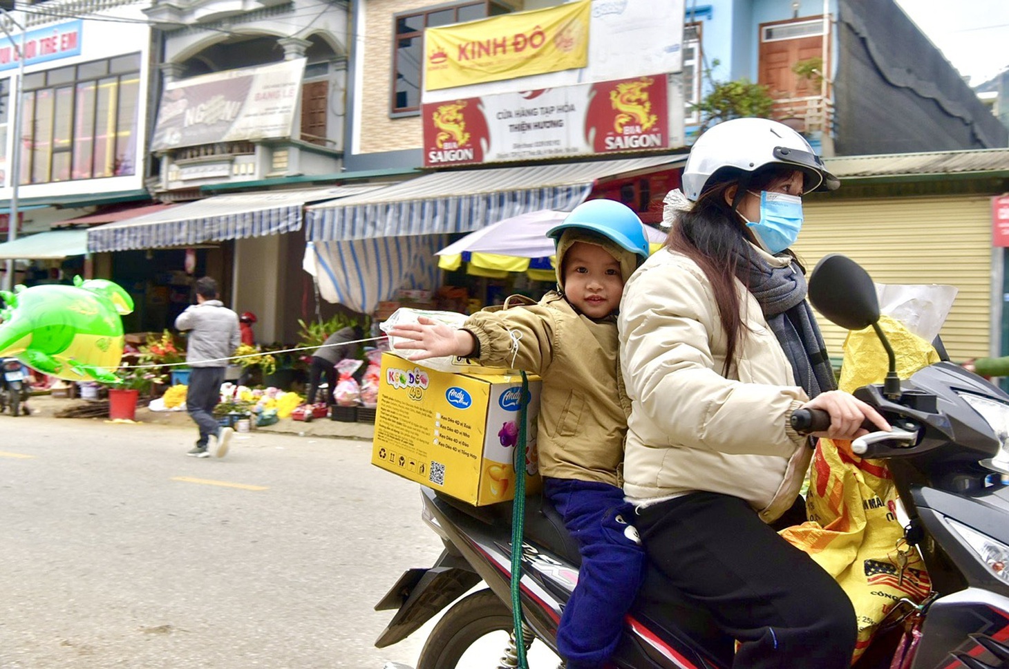 Bé con thích thú được mẹ mua cho bóng bay - Ảnh: T.T.D.