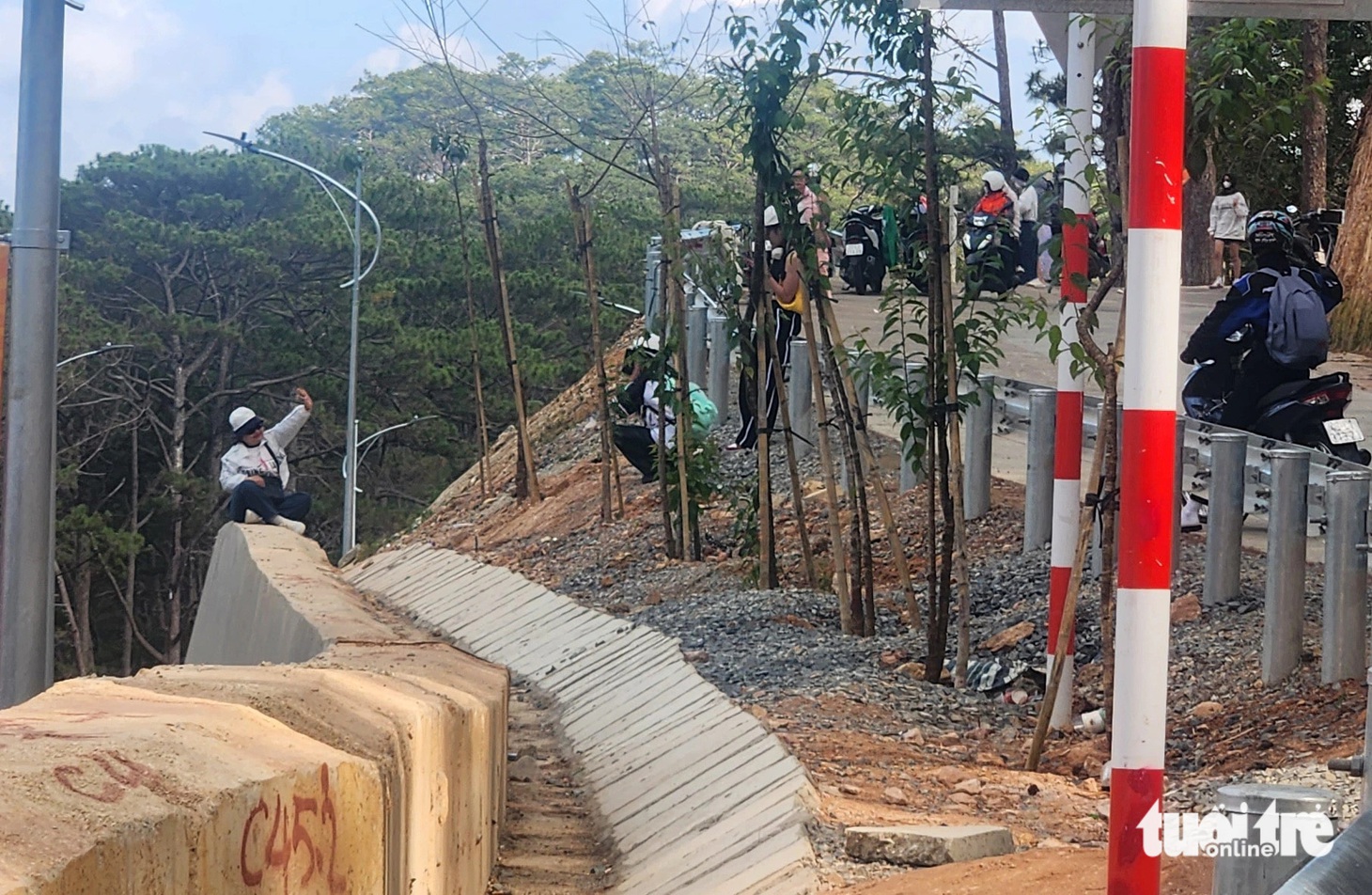 Ngồi vắt vẻo trên ta luy cao hơn 6m để chụp ảnh - Ảnh: M.V.