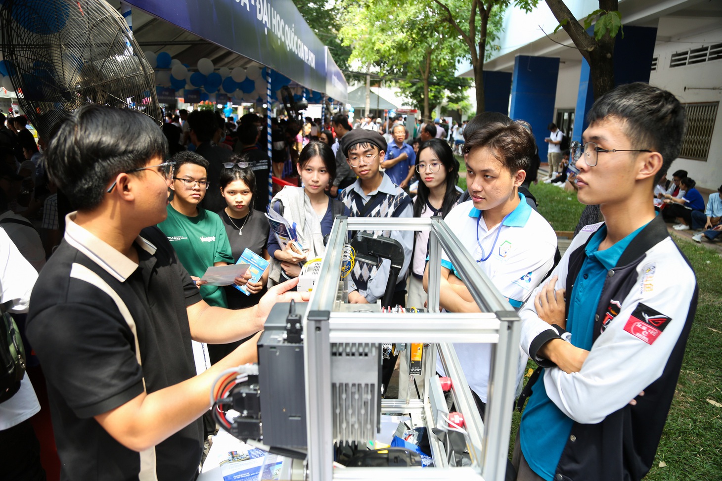 Bạn Hoàng Anh giới thiệu đến các em học sinh một mô hình thuộc ngành kỹ thuật - điện tử của sinh viên Trường đại học Bách khoa - Ảnh: PHƯƠNG QUYÊN