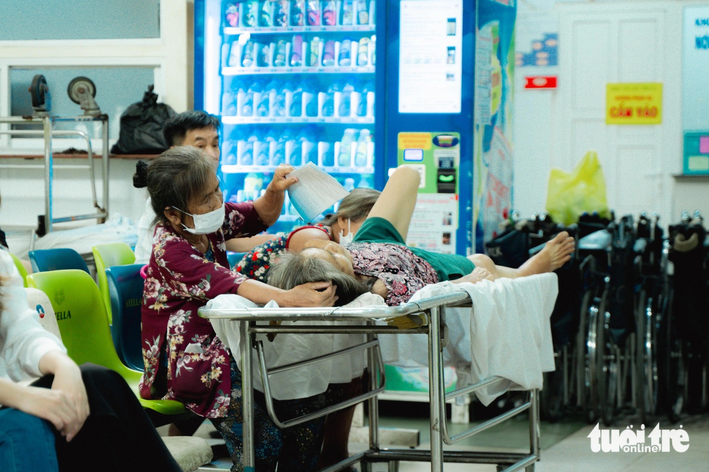 Cô Lan dùng sổ khám bệnh để quạt cho mẹ trong lúc chờ đến lượt khám tại Bệnh viện Chấn thương chỉnh hình TP.HCM