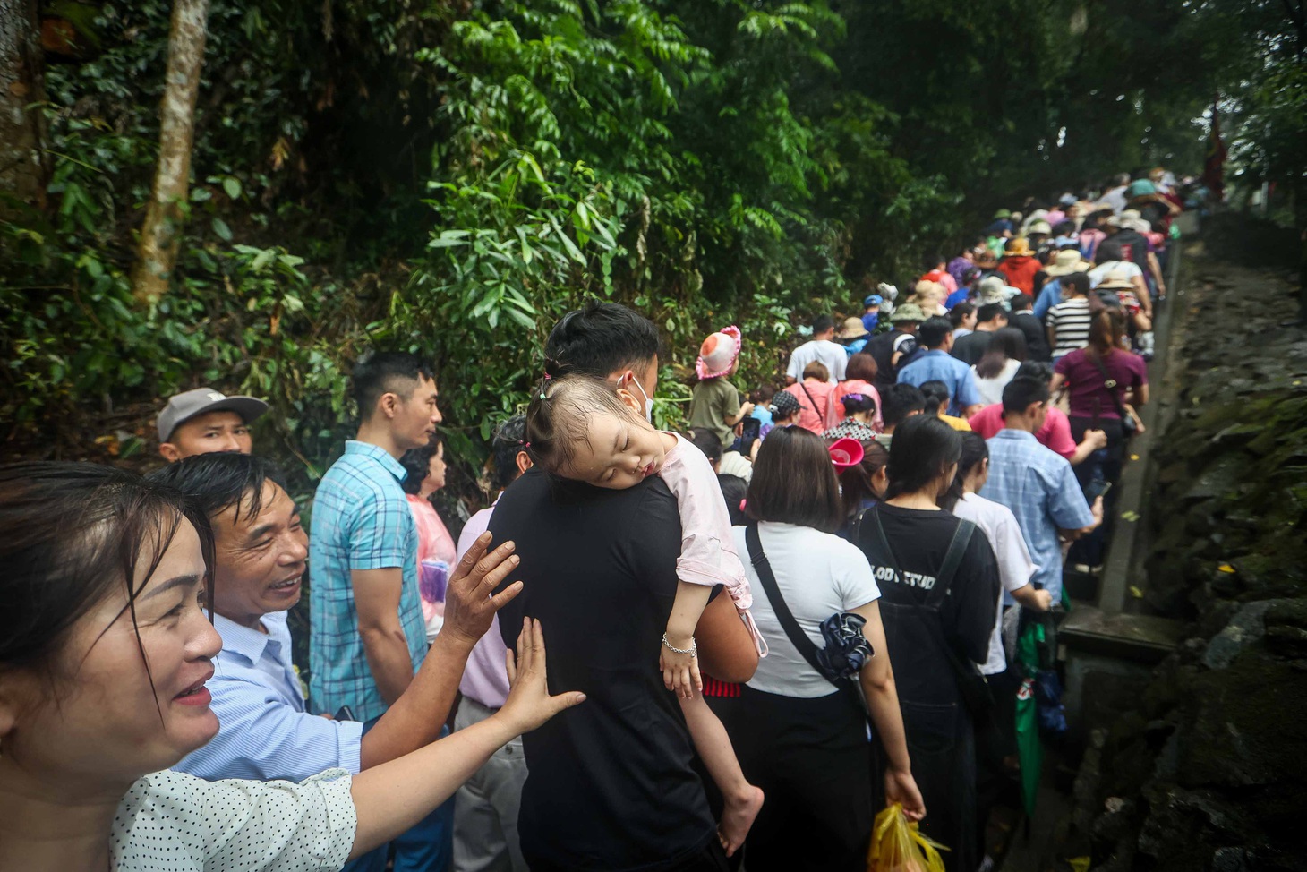 Do chờ đợi quá lâu, một bé gái đã ngủ trên vai bố khi trên đường lên Đền Hùng - Ảnh: NGUYỄN KHÁNH