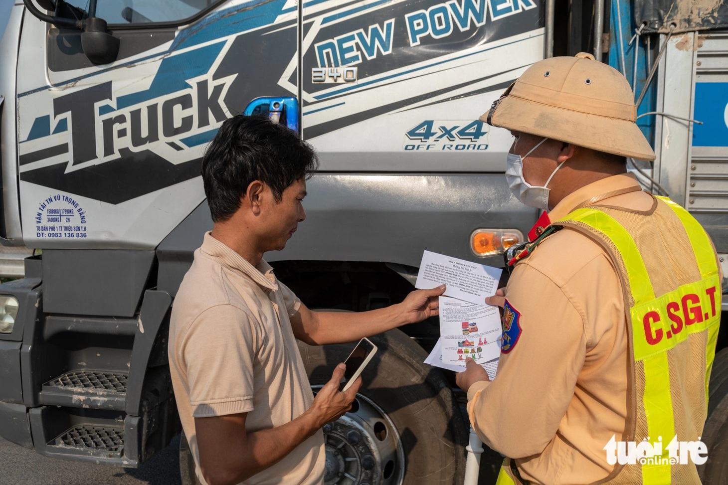 Cảnh sát giao thông phát tờ rơi hướng dẫn cách xử lý sự cố kèm số điện thoại lực lượng chức năng cho tài xế lưu thông trên cao tốc Cam Lộ - La Sơn - Ảnh: HOÀNG TÁO