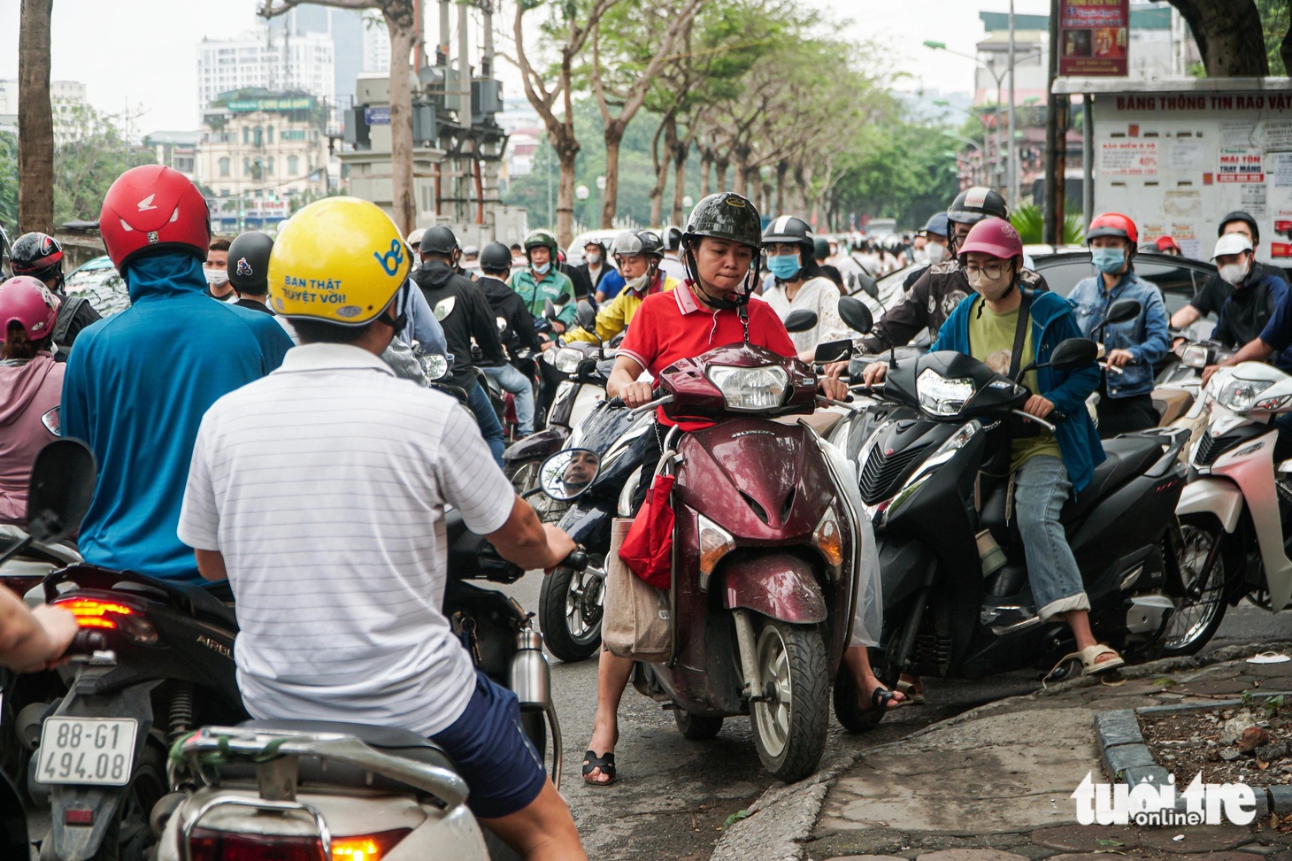Một người dân leo lên vỉa hè tìm lối đi - Ảnh: PHẠM TUẤN