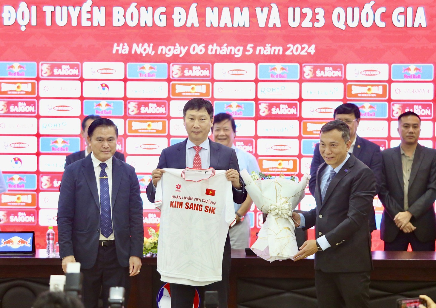 HLV Kim Sang Sik nhận hoa và áo từ lãnh đạo VFF - Ảnh: HOÀNG TÙNG