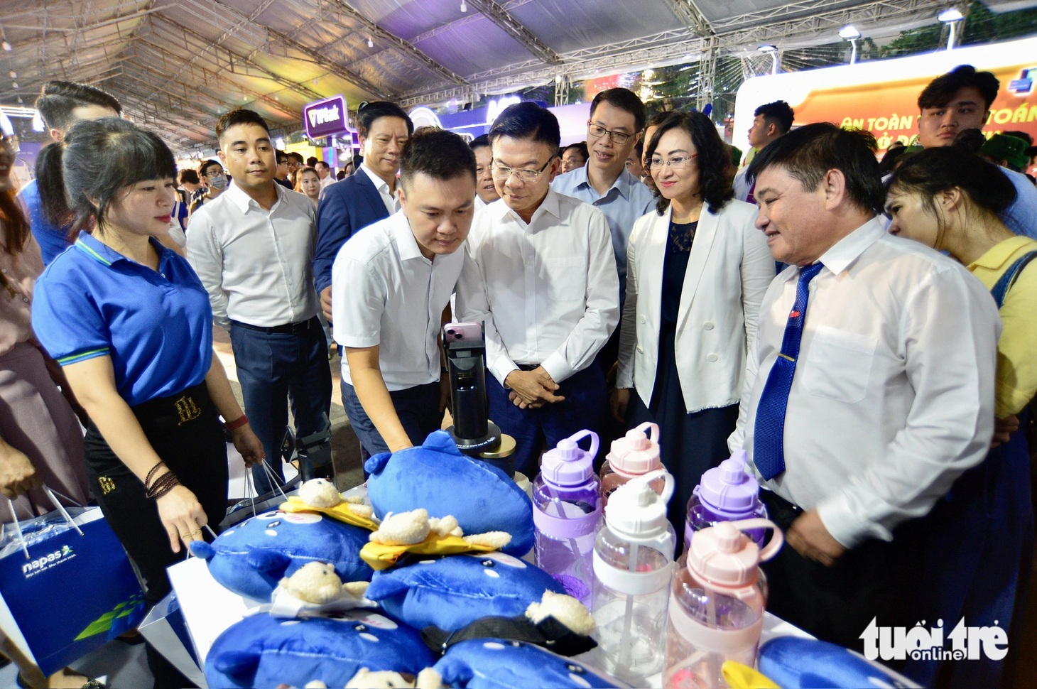 Phó thủ tướng Lê Thành Long và các đại biểu xem thanh toán bằng công nghệ xác thực sinh trắc học tại gian hàng NAPAS tại lễ khai mạc. Với 3.000 phần quà mà NAPAS đã mang đến lễ hội cũng đã hết sạch từ chiều 16-6. Đại diện NAPAS cho biết những kết quả của chương trình cho thấy thương hiệu Ngày không tiền mặt đã đi vào lòng người và Lễ hội Không tiền mặt đã trở thành ngày hội chung của mọi người dân. Ngày hội không chỉ là nơi người dân đến để vui chơi mà còn là nơi để người dân trải nghiệm những công nghệ thanh toán mới, tìm hiểu thêm những kỹ năng, nâng cao khả năng bảo mật, an toàn trong thanh toán online - Ảnh: QUANG ĐỊNH