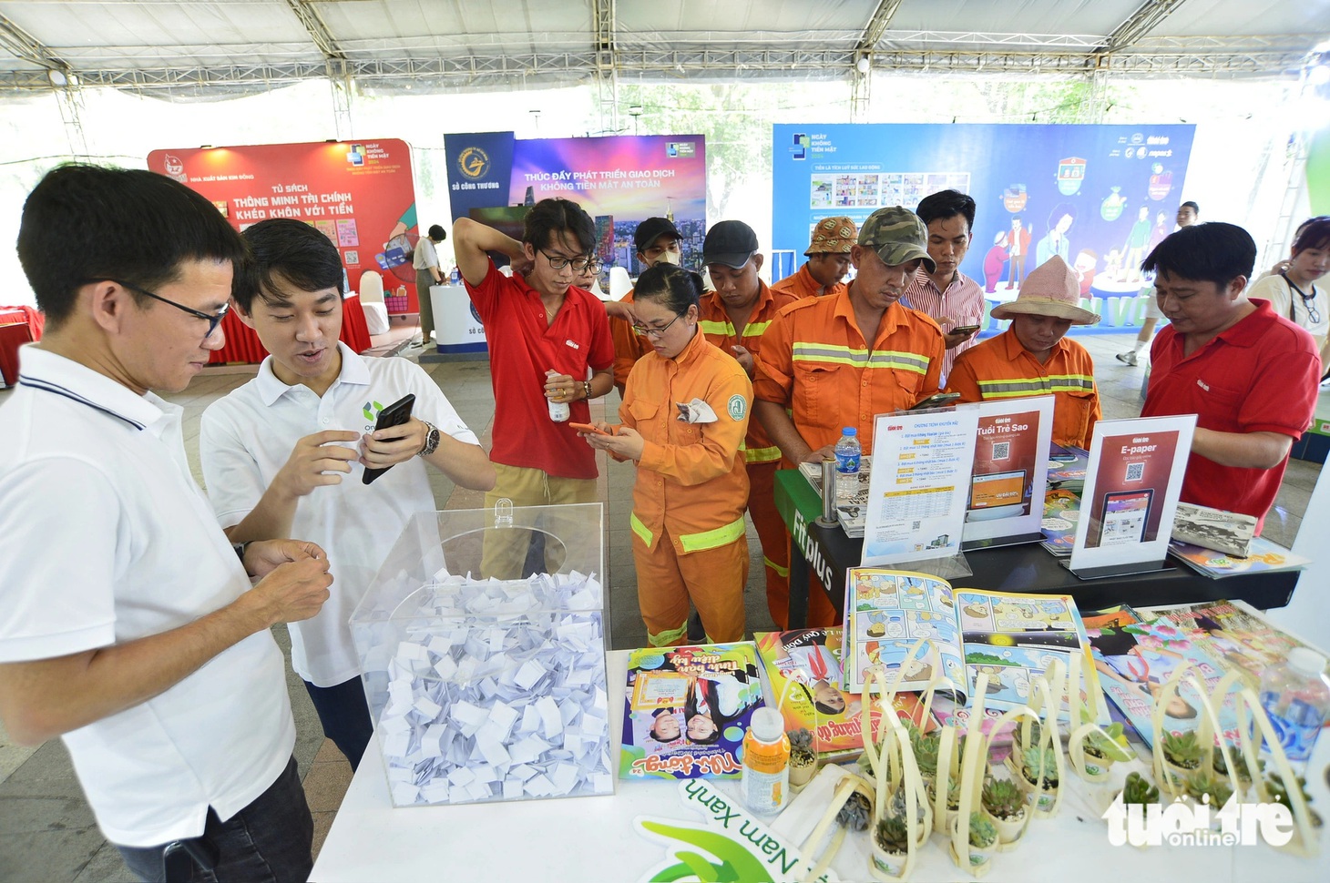 Những người dân, anh chị đơn vị phụ trách vệ sinh, dọn rác tại lễ hội trải nghiệm các tiện ích và đăng ký thành viên Tuổi Trẻ Sao tại không gian của báo Tuổi Trẻ - Ảnh: QUANG ĐỊNH