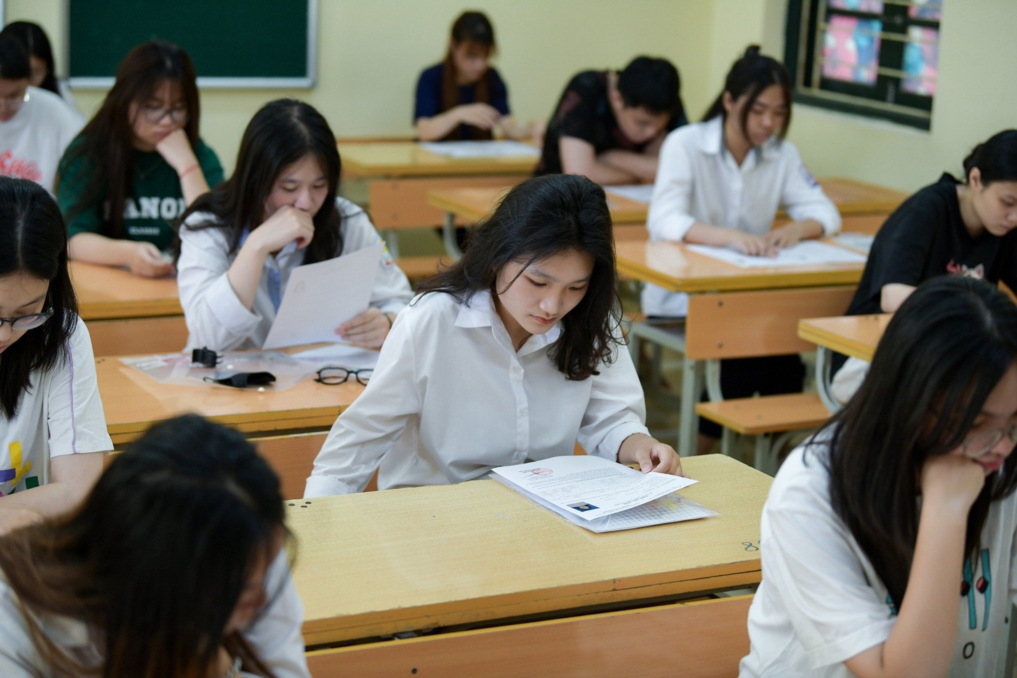Thí sinh lắng nghe giám thị phổ biến qui chế thi và xem lại những nội dung còn thiếu sót tại điểm thi Trường THPT Phan Huy Chú, Đống Đa, Hà Nội - Ảnh: NAM TRẦN