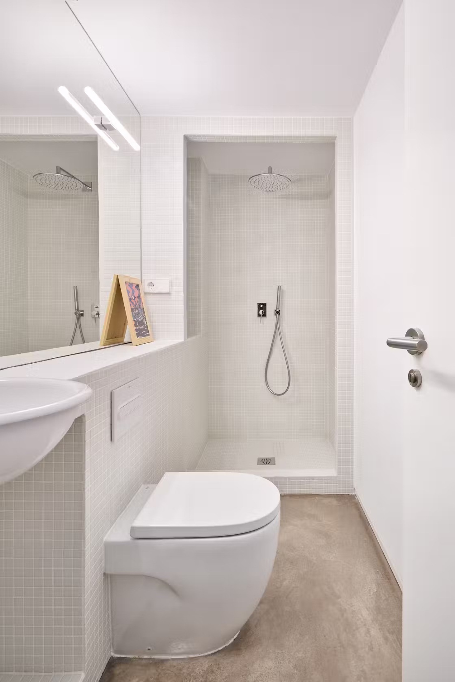Nhà vệ sinh nhỏ sạch sẽ và tiện ích với gam màu trắng sáng - Ảnh: dwell